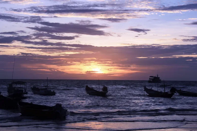 Sunset over Sairee Beach with longtail boats